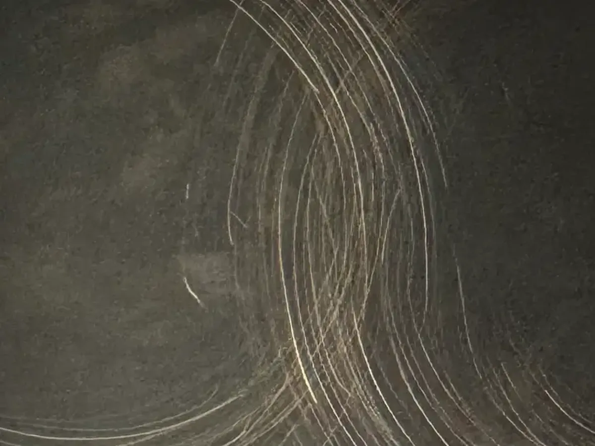 Blackened aged metal surface sample with subtle linear texture